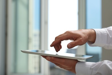 Photo of Closeup view of man using new tablet indoors