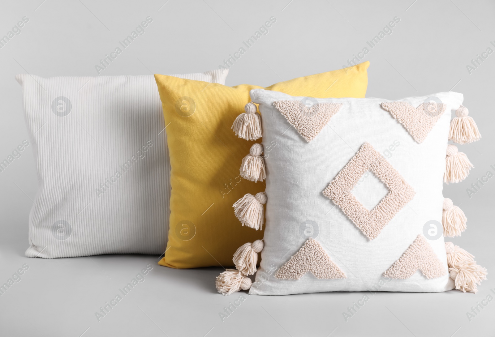 Photo of Different stylish soft pillows on grey background