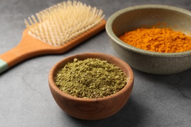 Comb, henna and turmeric powder on light grey table