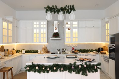 Photo of Cozy spacious kitchen decorated for Christmas. Interior design