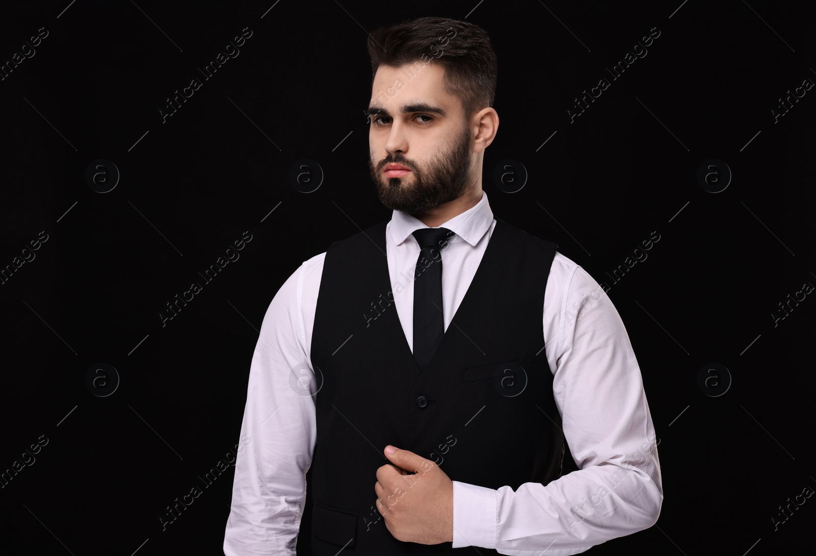 Photo of Handsome businessman in suit and necktie on black background