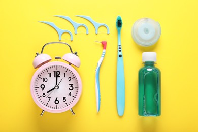 Dental floss, toothbrushes and mouthwash on yellow background, flat lay