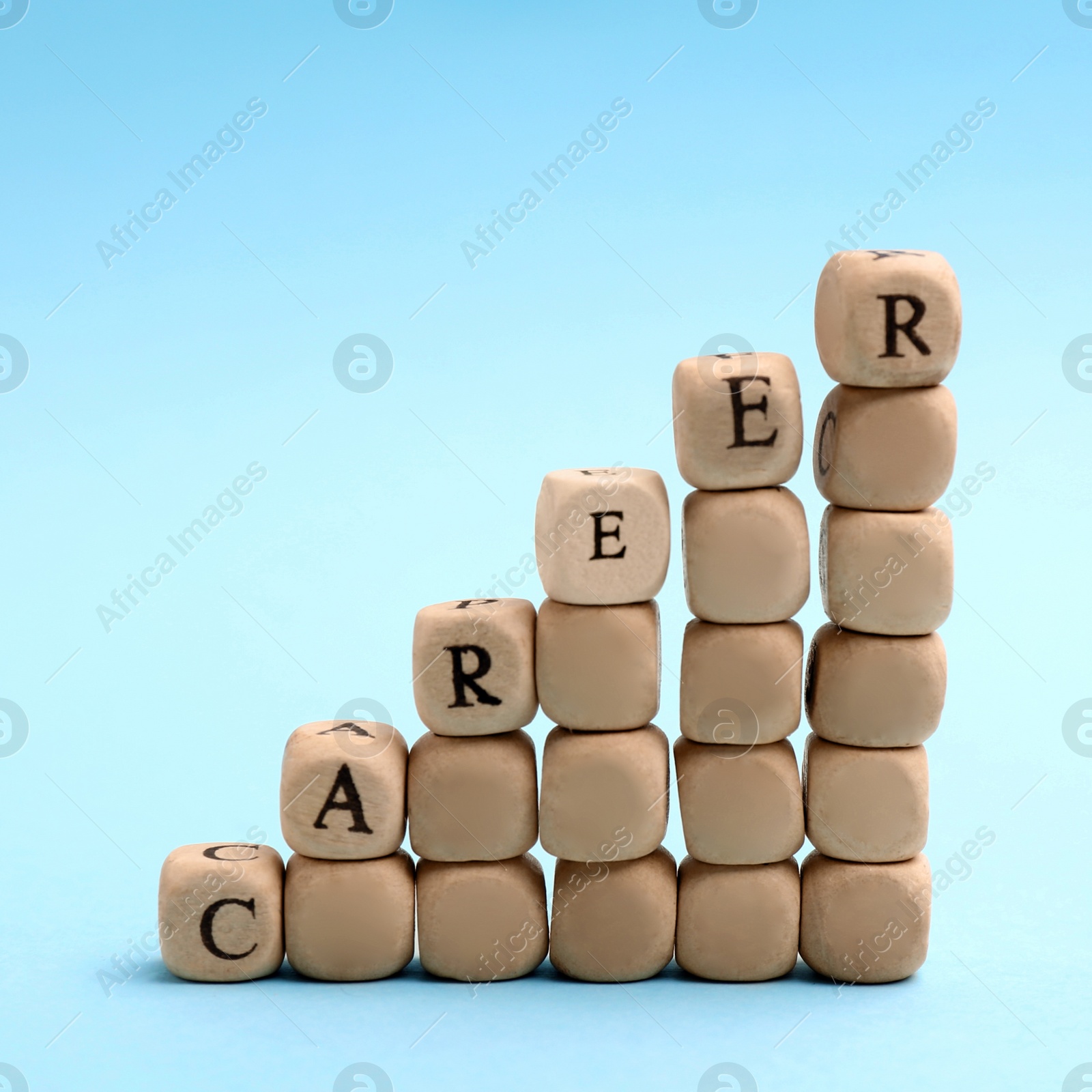 Photo of Wooden beads with word CAREER on light blue background. Promotion concept