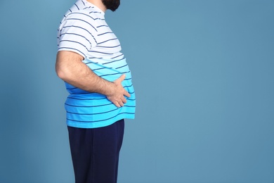 Overweight man on color background