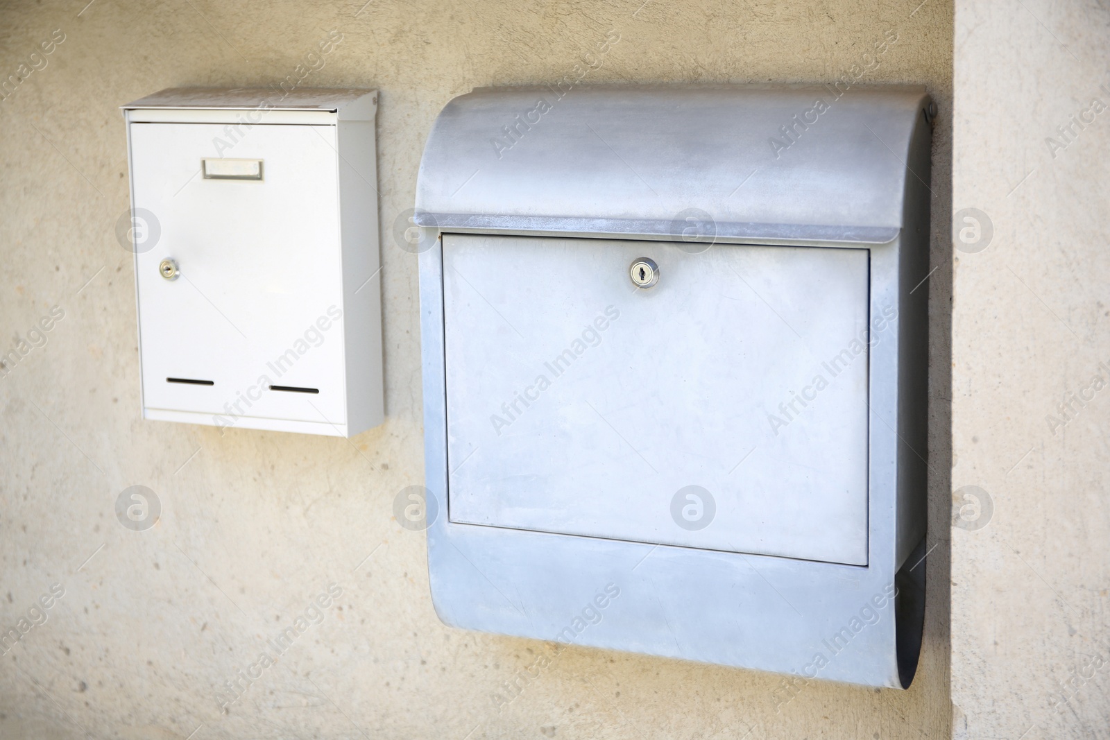 Photo of White metal letter boxes on beige wall