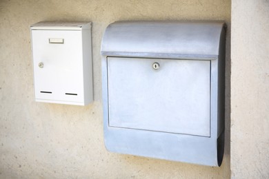 Photo of White metal letter boxes on beige wall