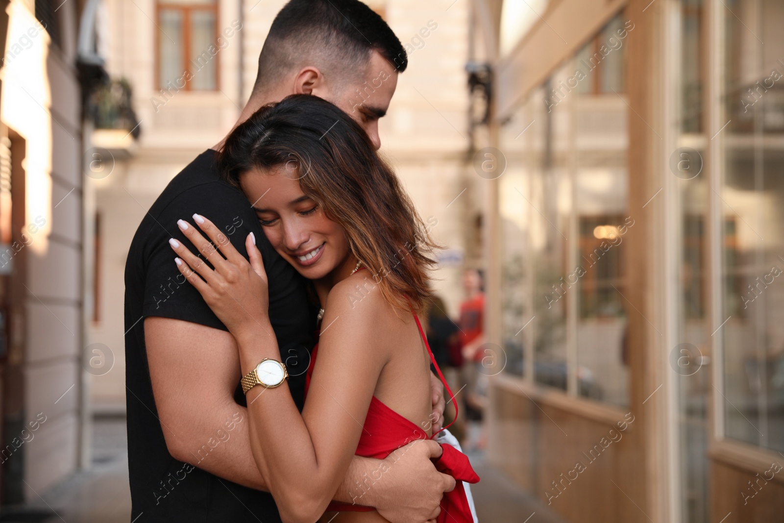 Photo of Happy young couple hugging on city street