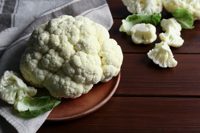 Photo of Plate with fresh raw cauliflower on wooden table