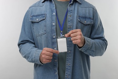 Man with blank badge on grey background, closeup