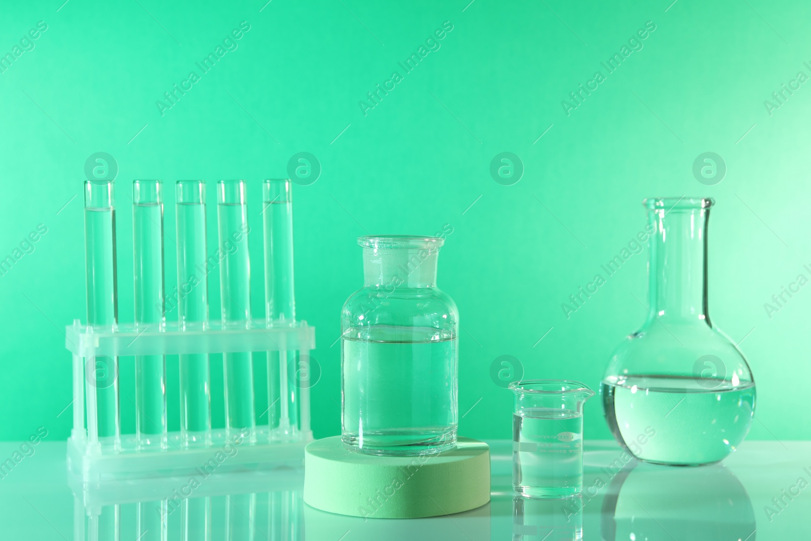 Photo of Laboratory analysis. Different glassware on table against green background