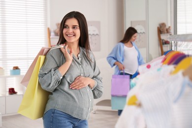 Photo of Happy pregnant woman with shopping bags in store