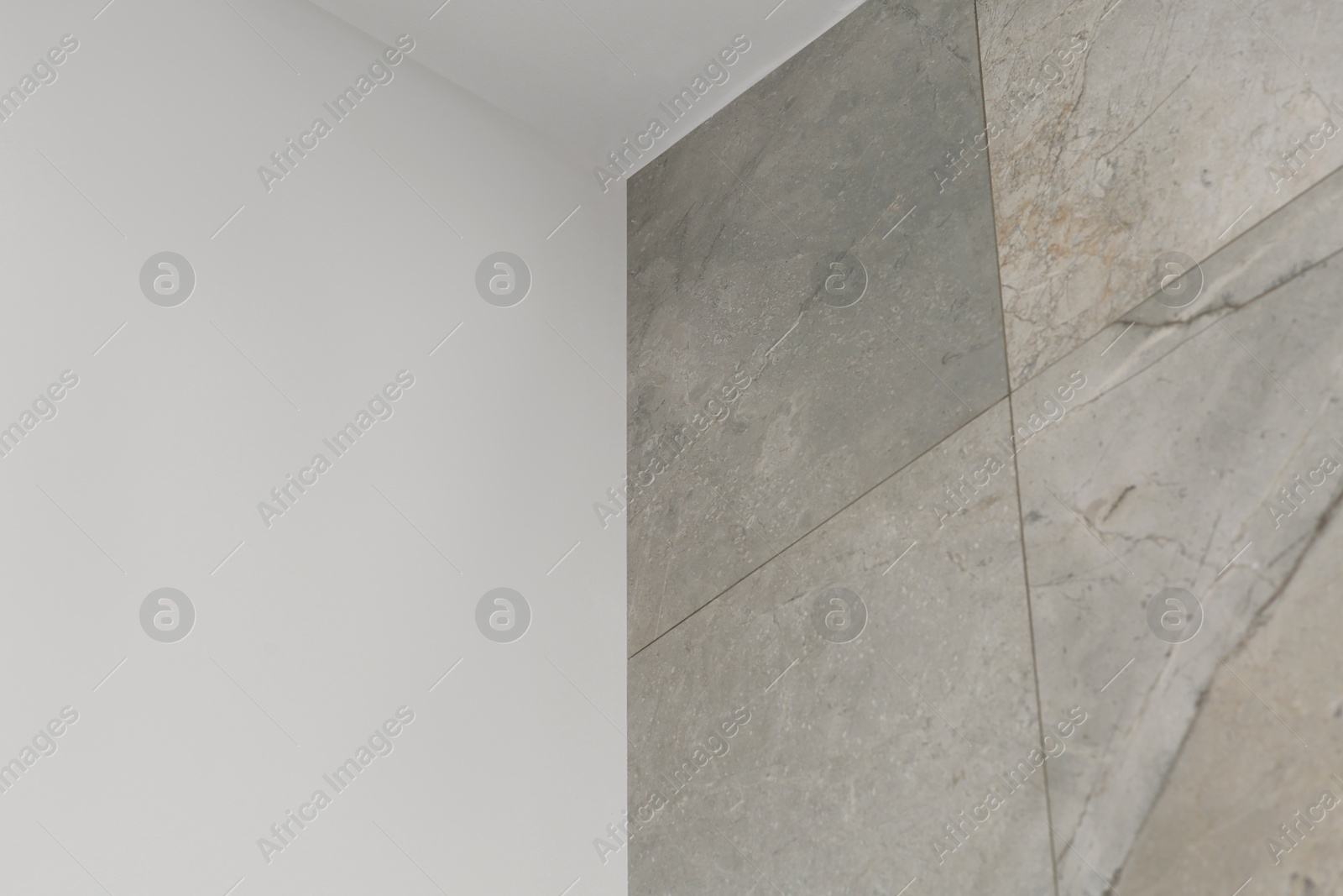 Photo of Wall with beautiful light gray marble tiles indoors, low angle view