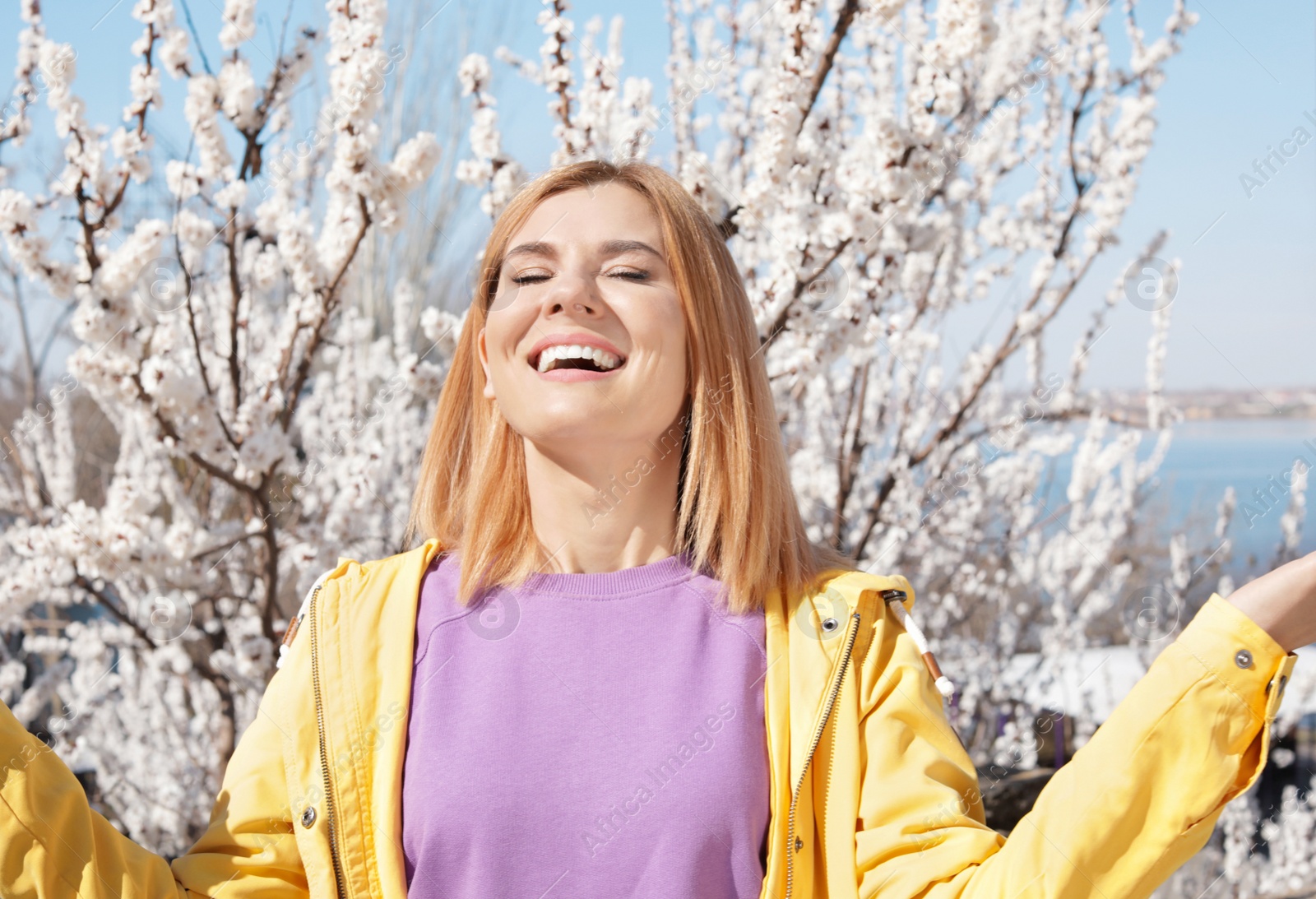 Photo of Happy healthy woman enjoying springtime outdoors. Allergy free concept