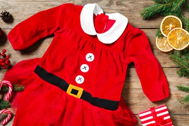 Flat lay composition with Christmas baby clothes on wooden background