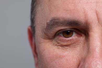 Photo of Closeup view of man with beautiful eyes on grey background