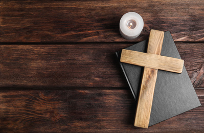 Photo of Cross, Bible and burning candle on wooden background, flat lay with space for text. Christian religion