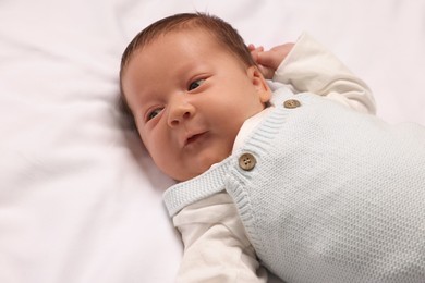 Photo of Cute newborn baby lying on white blanket