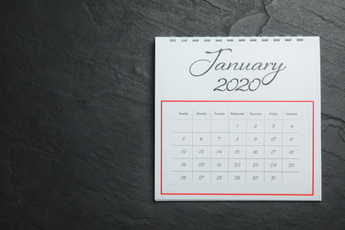 Photo of January 2020 calendar on black stone background, top view. Space for text