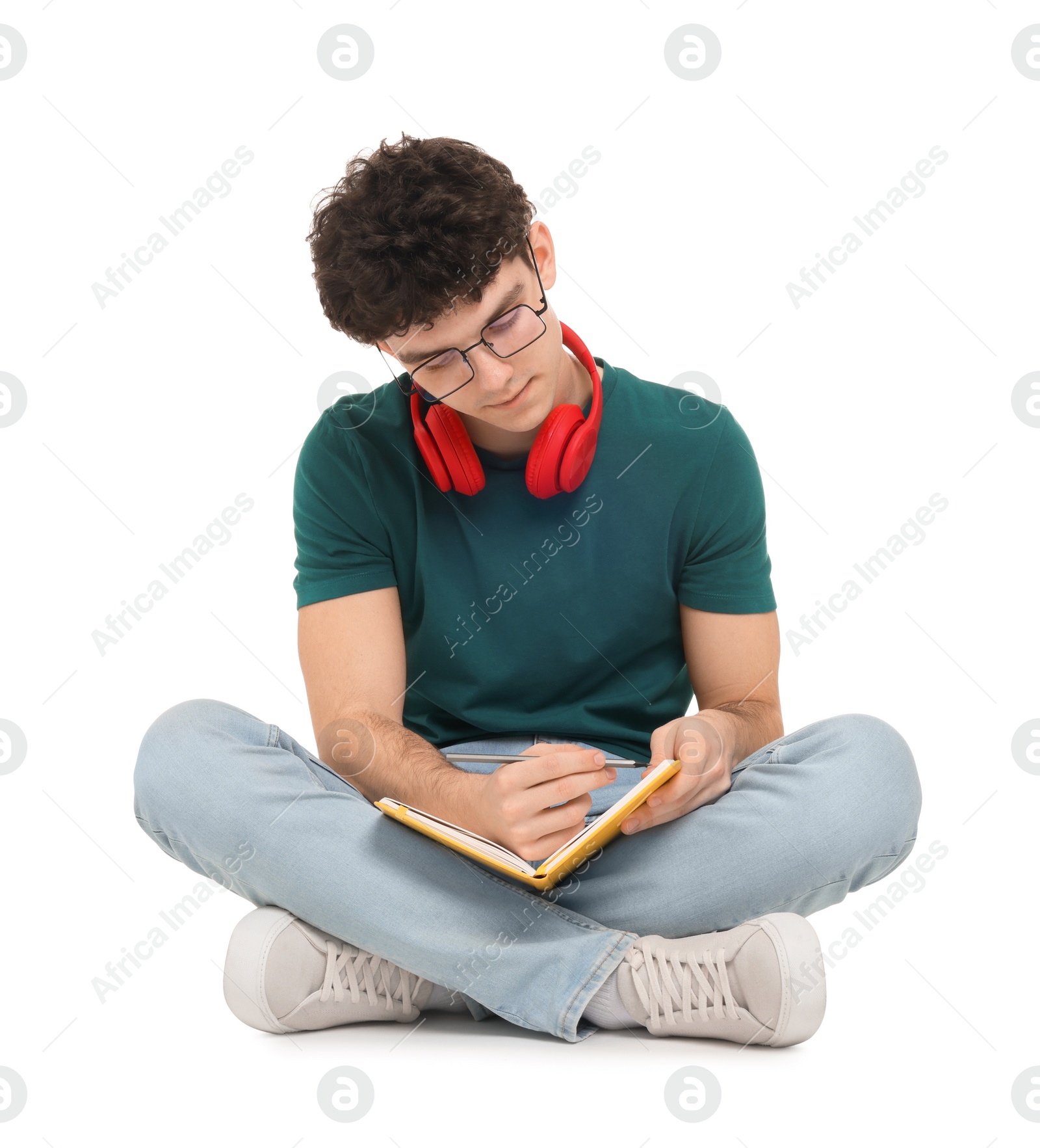 Photo of Portrait of student with notebook and headphones sitting on white background