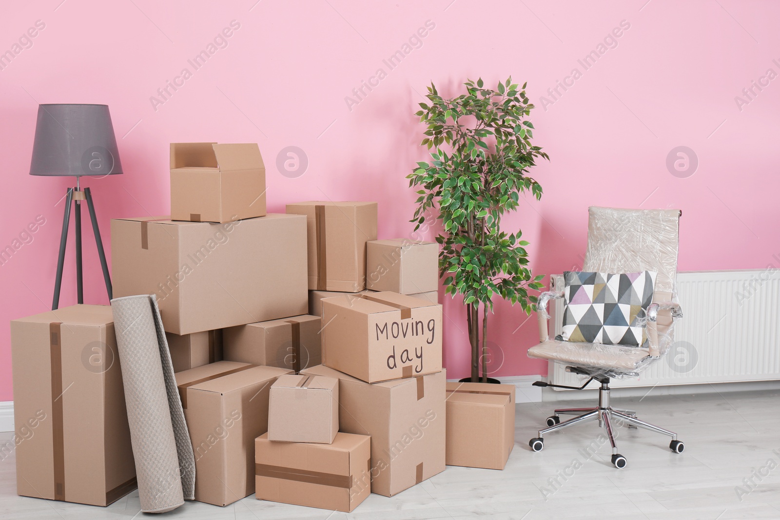 Photo of Cardboard boxes and household stuff in empty room. Moving day