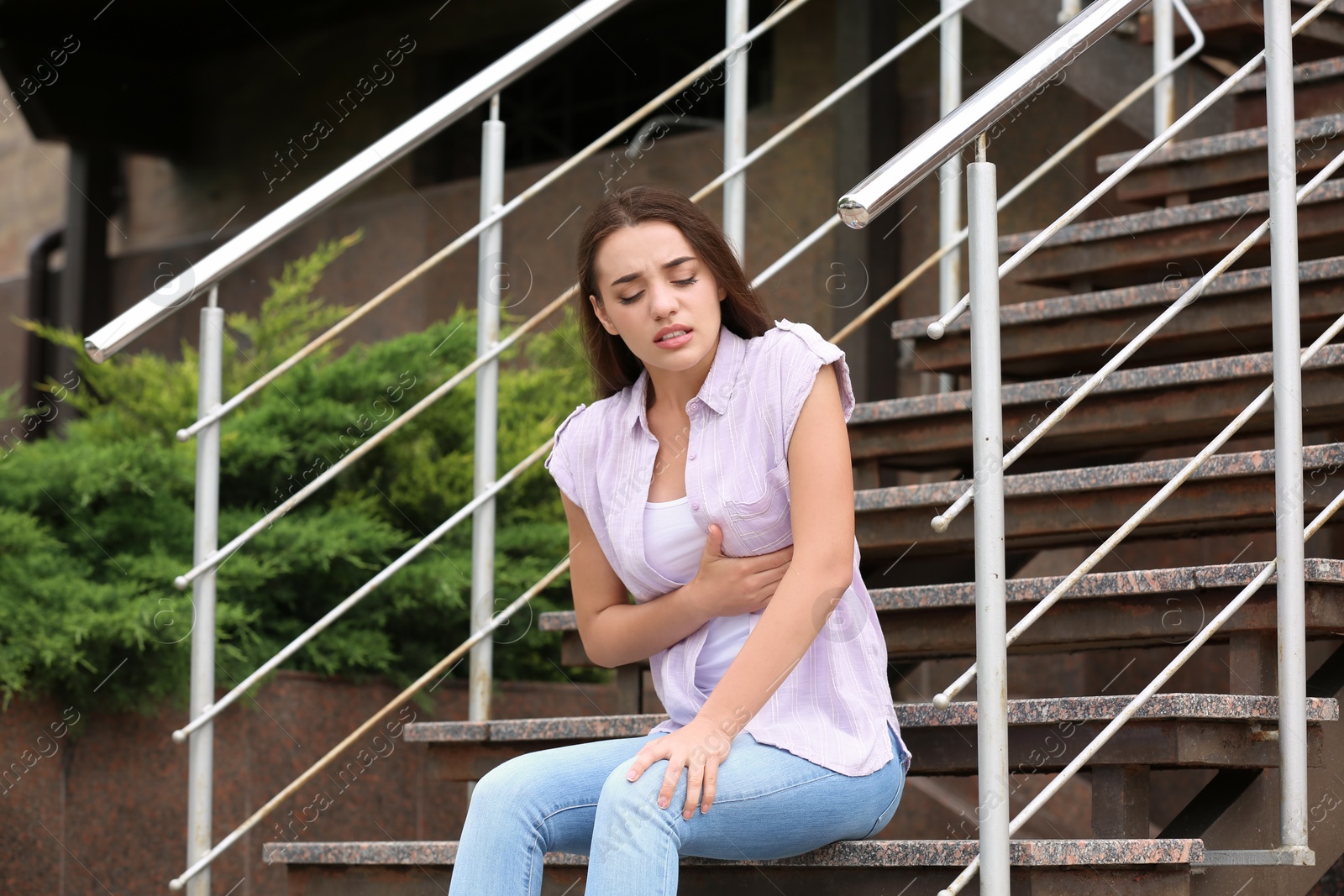 Photo of Young woman having chest pain outdoors. Heart attack