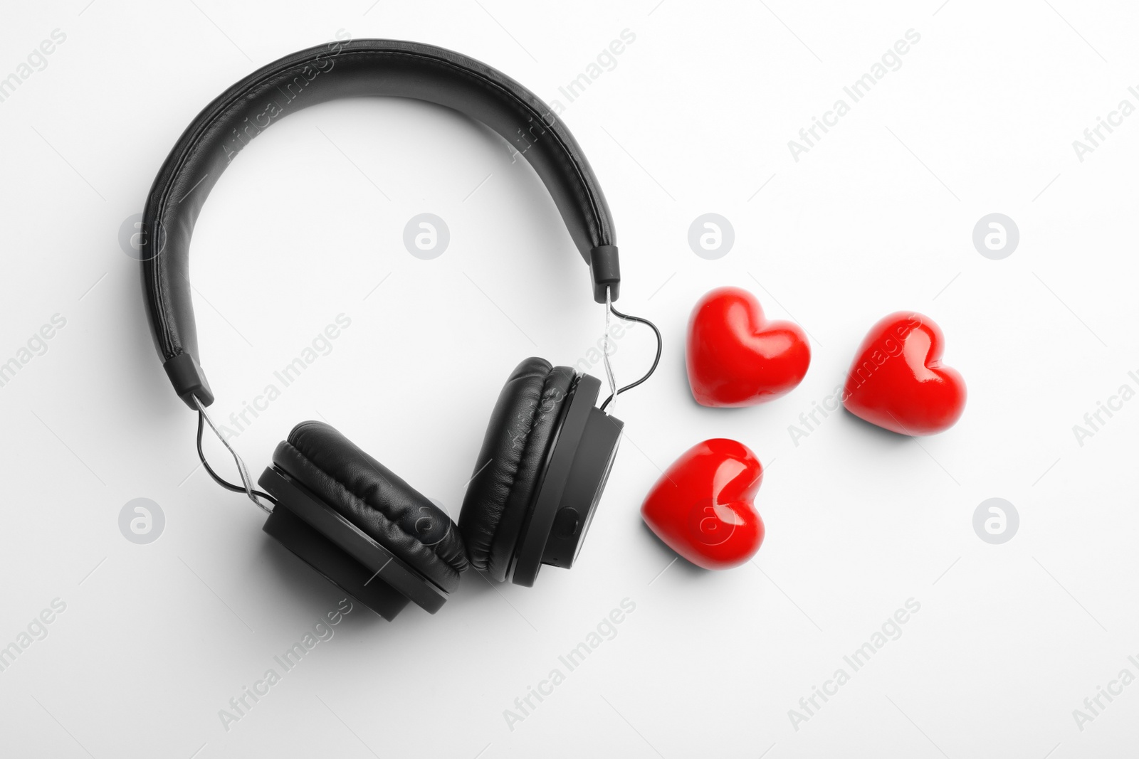 Photo of Decorative hearts and modern headphones on white background, top view