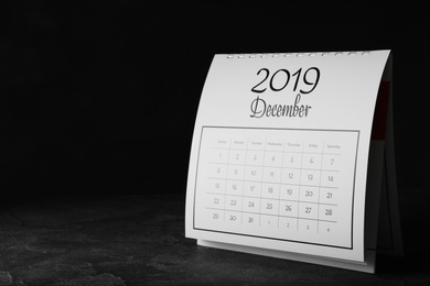 Paper calendar on grey table, space for text. Planning concept
