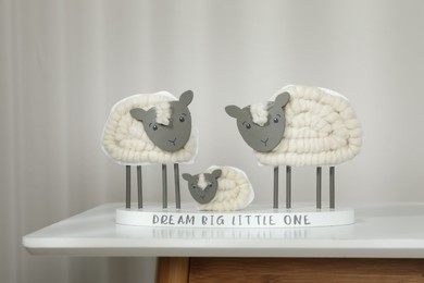 Cute decorative sheep and lamb figurine with phrase Dream Big Little One on white table against light background. Family Day