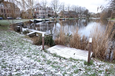 Picturesque view of water canal with moored boats in city on winter day