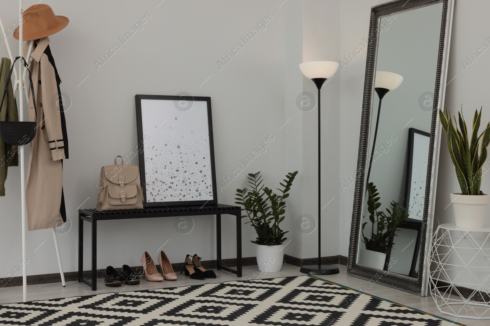 Photo of Stylish hallway room interior with bench, shoes, clothes rack and floor mirror