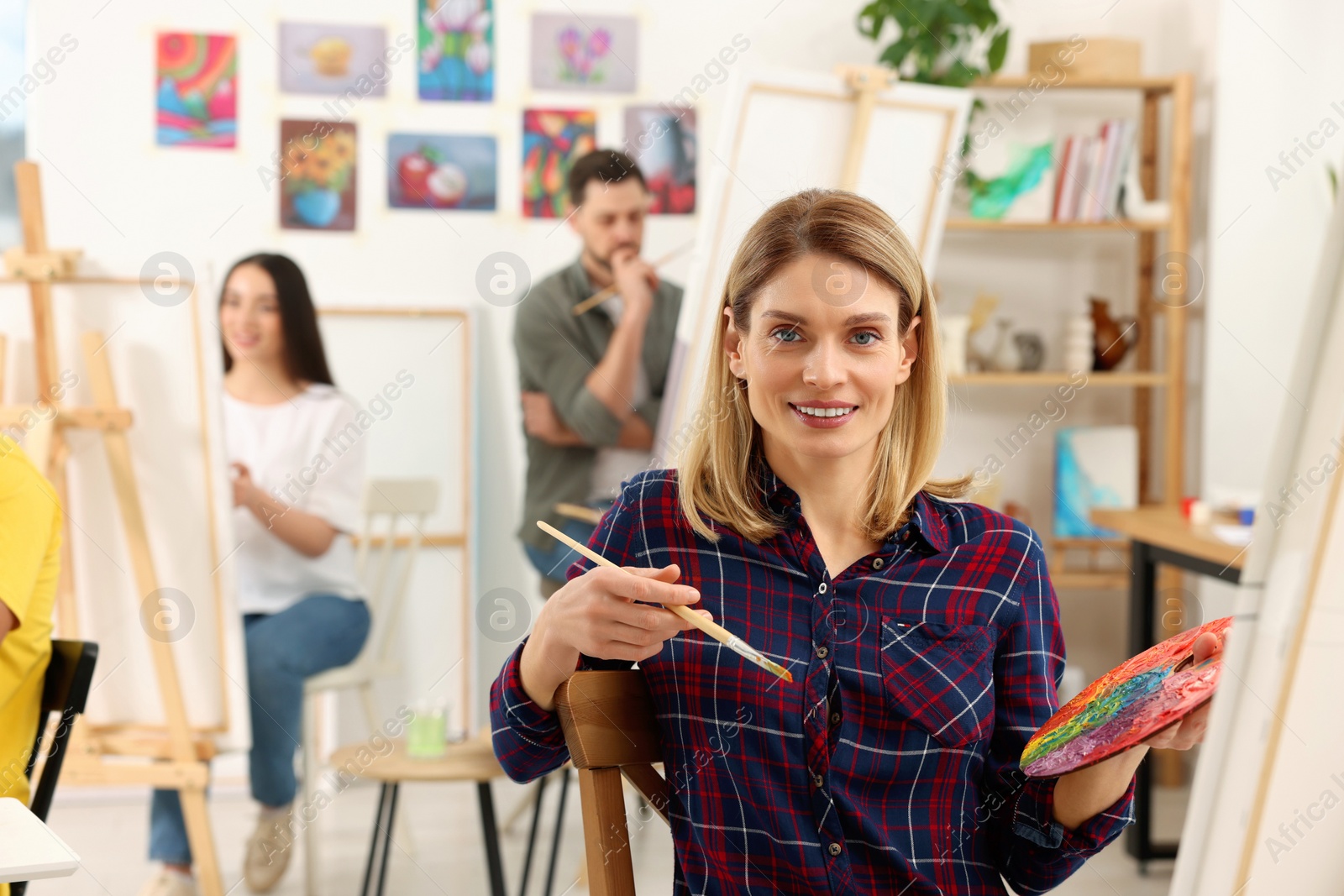 Photo of Group of students attending painting class in studio. Creative hobby