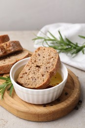 Photo of Bowl of organic balsamic vinegar with oil served with spices and bread slices on beige table