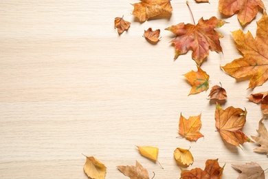 Photo of Flat lay composition with autumn leaves on wooden background. Space for text