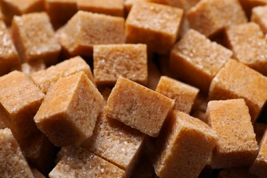 Photo of Many brown sugar cubes as background, closeup