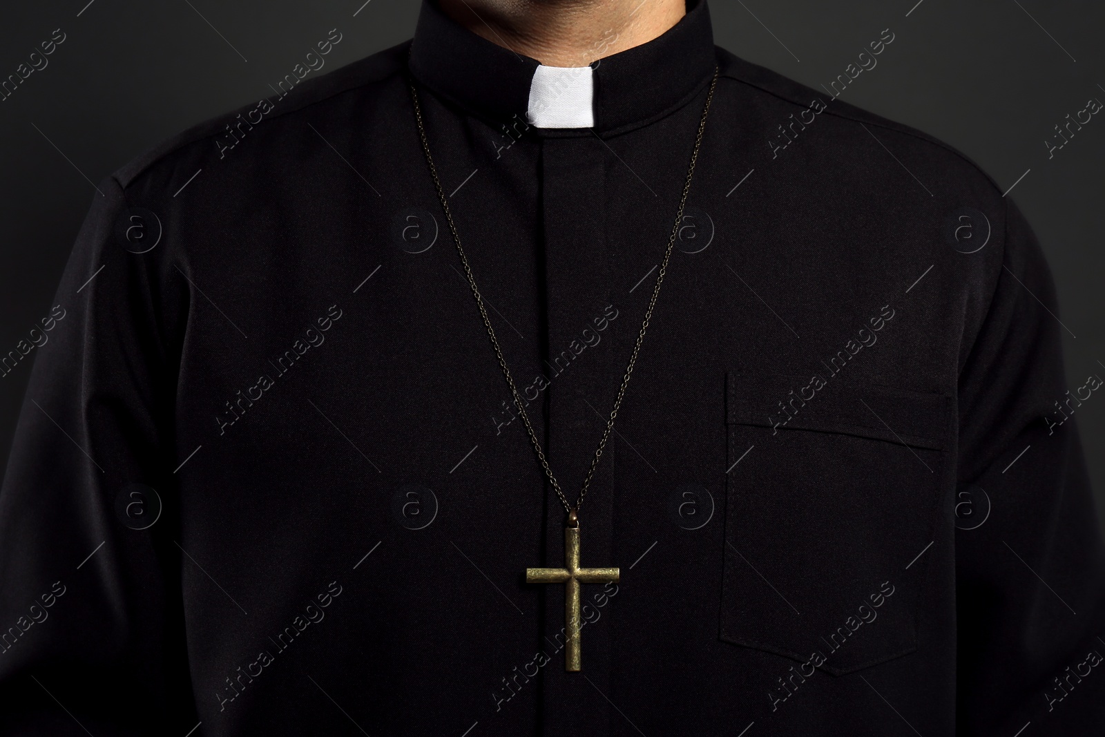 Photo of Priest with cross on black background, closeup