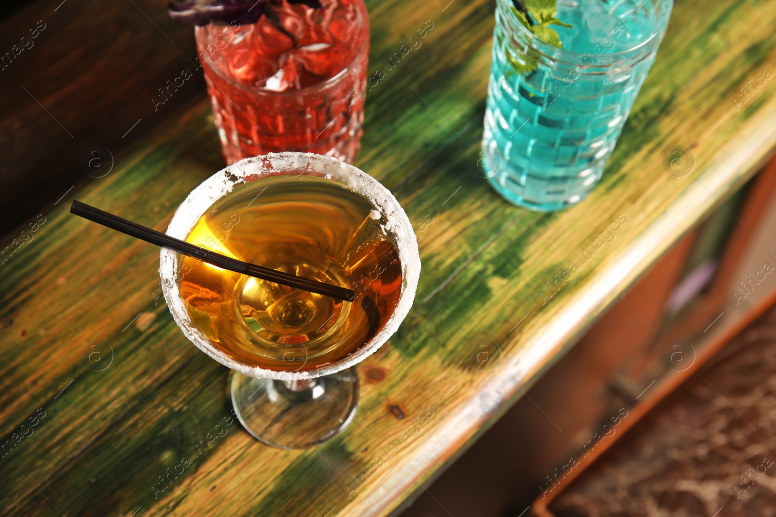 Photo of Glasses with delicious cocktails on counter in bar