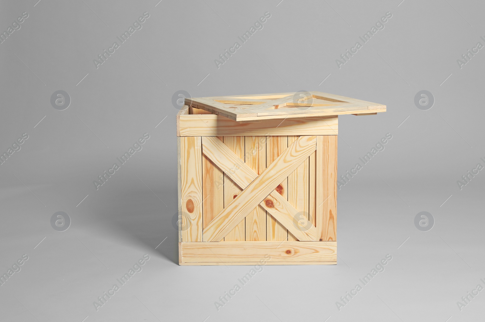 Photo of One open wooden crate on grey background