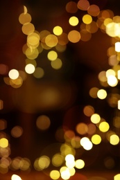Photo of Blurred view of glowing lights on color background. Winter holiday