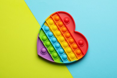 Photo of Heart shaped rainbow pop it fidget toy on color background, top view