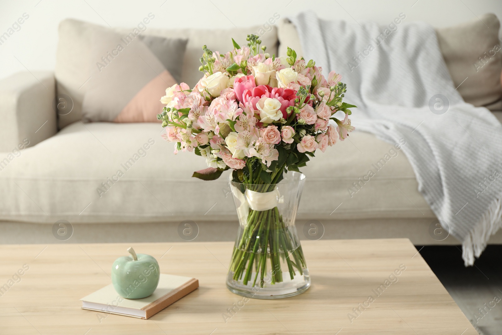 Photo of Beautiful bouquet of fresh flowers in vase on wooden table indoors