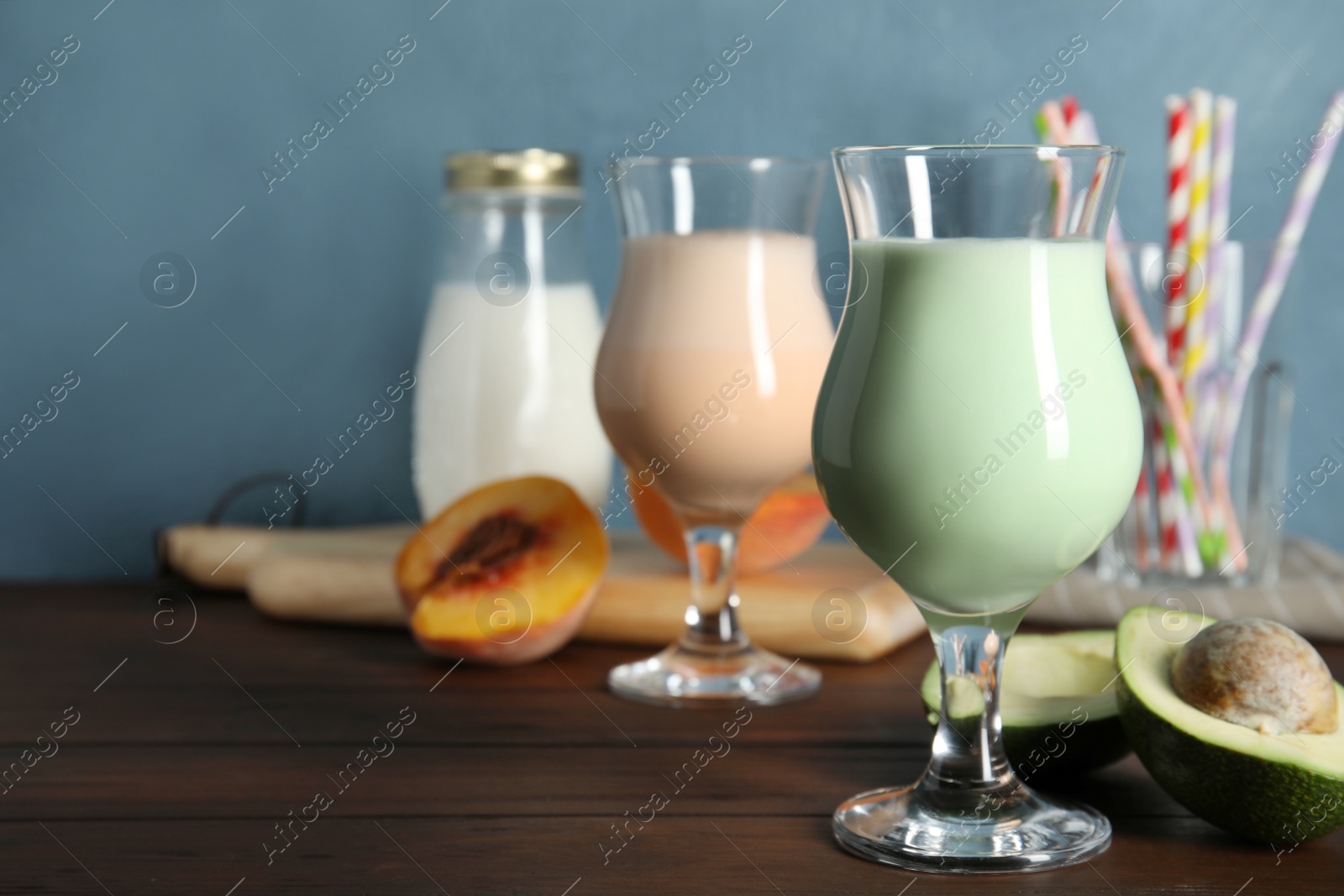 Photo of Glasses with delicious milk shakes and ingredients on table