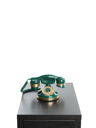 Green vintage corded phone on small black table against white background