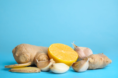 Photo of Fresh garlic and other natural cold remedies on light blue background. Space for text