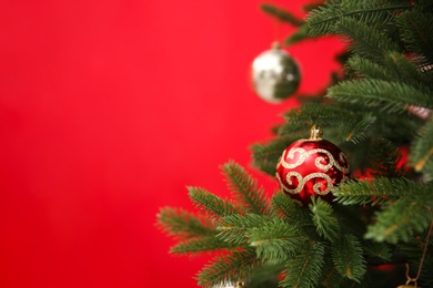 Beautifully decorated Christmas tree against color background, closeup