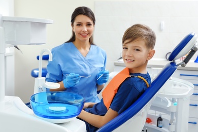 Photo of Professional dentist and little boy in clinic