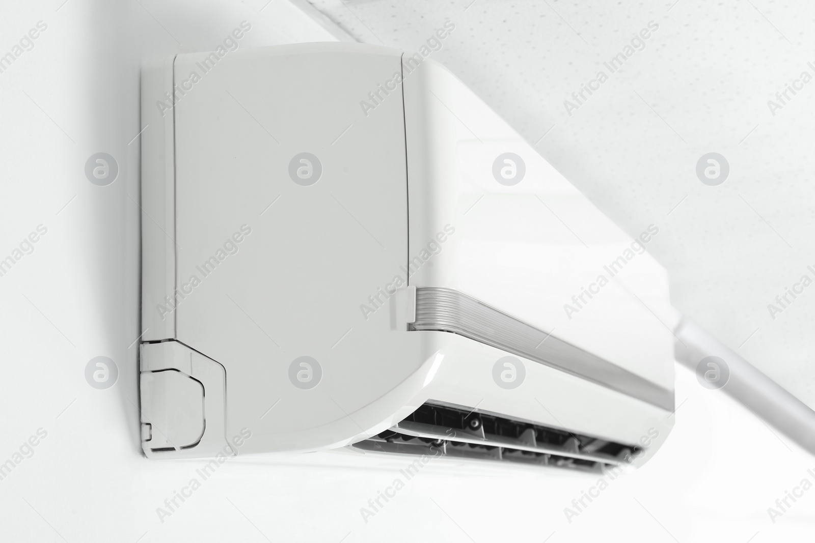 Photo of Modern air conditioner on white wall indoors, closeup