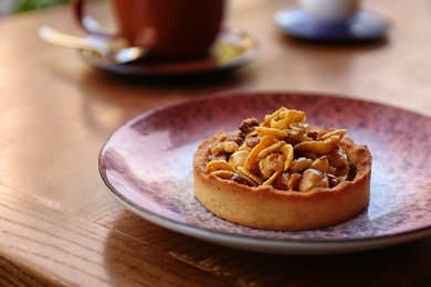 Photo of Plate with delicious cake on wooden table