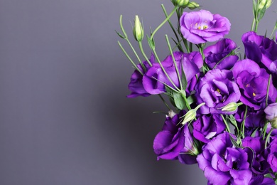 Photo of Beautiful bouquet of purple eustoma flowers and space for text on color background