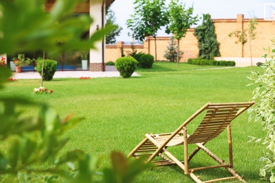 Wooden deck chair in beautiful garden on sunny day. Space for text