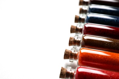 Glass bottles with different food coloring on white marble table, closeup. Space for text